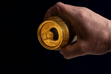 Male hand holding a can of beer with black background ,relaxing and refreshing enjoyment