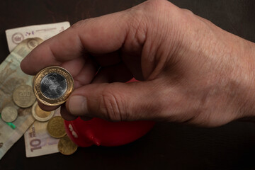 Man Holding Colombian Pesos in Hand