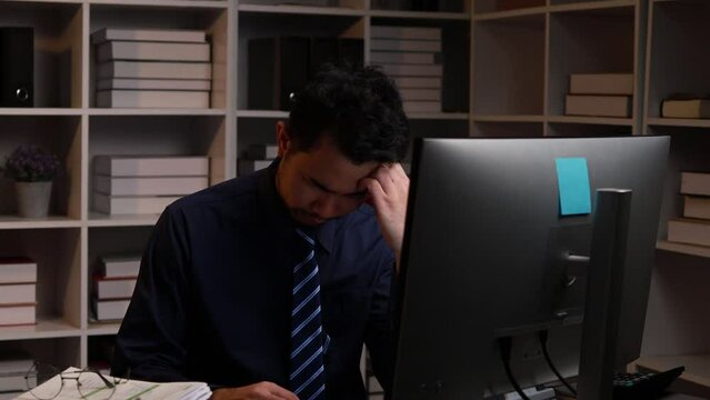 Businessman sitting at work stressed, startup company employee working in office with piles of work papers on desk, overtime. Document management concept.