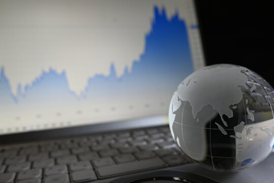 株価チャートとガラスの地球儀　世界経済のイメージ　Glass globe with graphs of stock prices