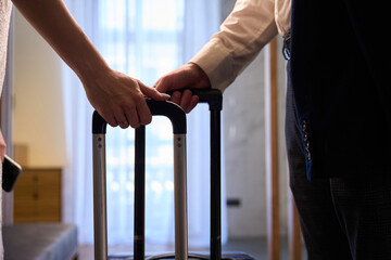 Close-up male and female hands holding suitcases, spending weekends together