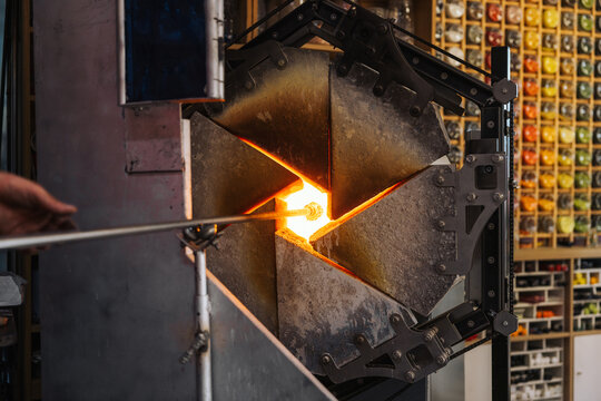Glassblower crafting a Christmas bauble, from the heat of the oven to shaping it. Workshop based in France.