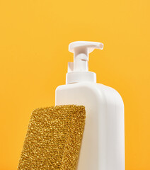 White detergent dispenser and abrasive dishwashing sponge gold color.