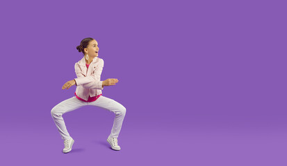 Fototapeta na wymiar Full body length shot of happy funny cheerful pretty little girl in light pink leather jacket and white jeans dancing on purple copy space background. Children's clothes, kid's fashion, sale concept
