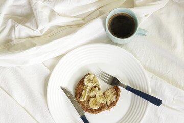 Healthy bed breakfast, banana, oats, hot cakes with coffee on a blue cup 