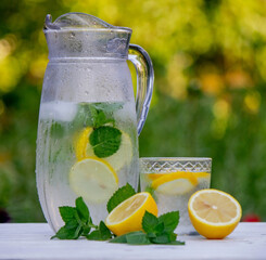 Cold lemonade with fresh lemon and crushed ice cubes. Selective focus.