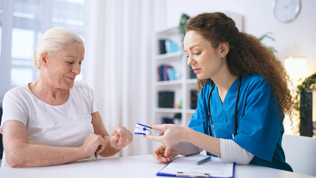 Female general practitioner measuring oxygen saturation level of a senior patient
