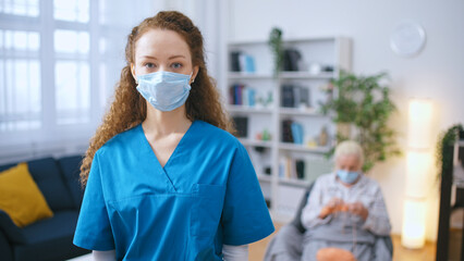 A portrait of a nurse in a protective face mask within a nursing home, highlighting the challenges...