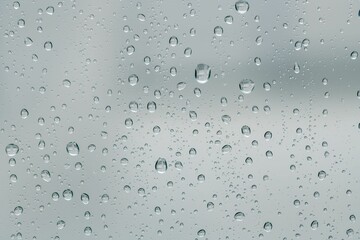 a view through the glass of a rain covered window with water droplets