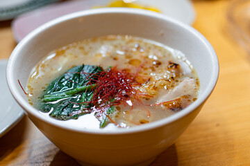 Hand with chopsticks takes noodles of ramen soup. Traditional Asian cuisine