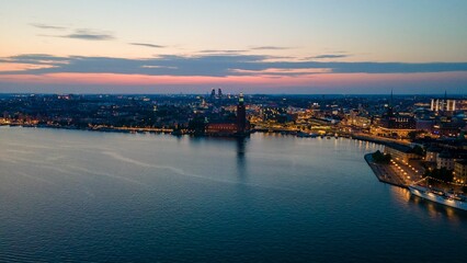 Obraz premium a sunset at the edge of a body of water next to a city