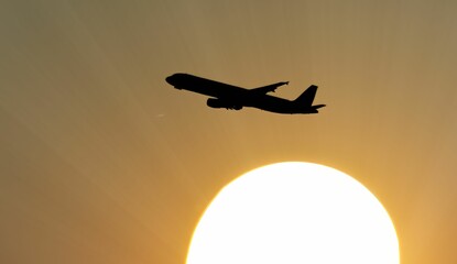 Silhouette of an airplane taking off at sunset.