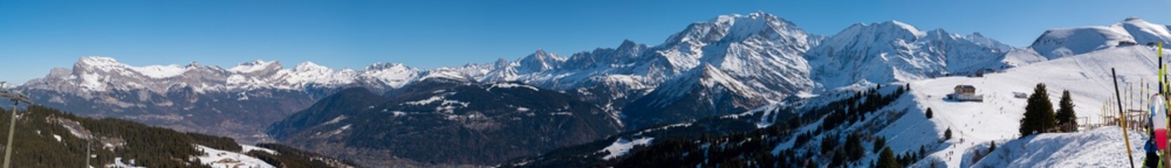 Majestic snow-capped Mont Blanc mountain range, with lush evergreen trees dotting the landscape