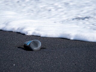 Stunning vista of a black sand beach adorned with rolling blue ocean waves