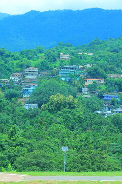 A beautiful view of the sky, buildings on green hills.