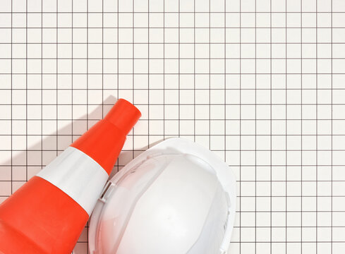 Orange bright construction cone and a white protective helmet for the head. Flat lay, copy space for text.