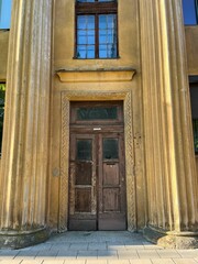 Building in Kaunas, Lithuania boasting intricate architecture and columns against a vibrant blue sky