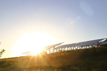 Photovoltaic batteries on orange bright sunset. Counter light, Solar panels. The concept of alternative energy