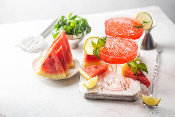 Watermelon frozen cocktail margarita with fresh watermelon, lime and mint on white background