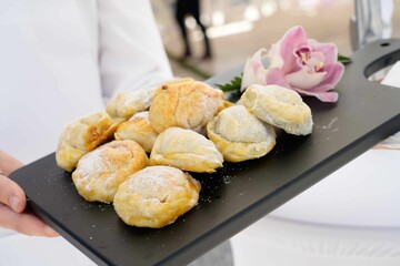 Closeup of a chef holding a tray with fresh pastries