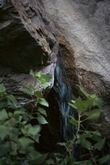 A waterfall, with rocky outcroppings and lush green trees surrounding the area, Angeles forest © Zhijin Shen/Wirestock Creators