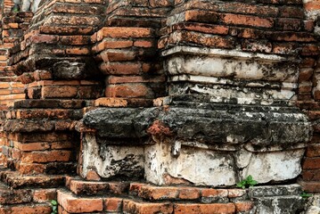 Weathered brick wall with a cracked surface on an abandoned building