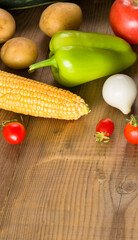 A set of vegetables on a wooden table. Vertical photo.
