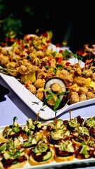 Close-up of fourchette table with various appetizers arranged on multiple trays and plates