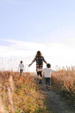 Mother and children walking happily in a field in Autumn