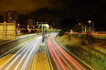 houses and buildings and a view of the road of the night city with a view of the residual light of the headlights of passing cars