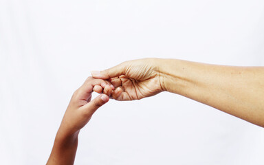 Adult reaching out, raising child's hand over white background

