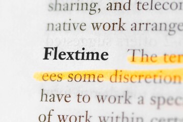Close-up of a business textbook with the term 'flextime' highlighted and focused
