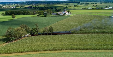 Obraz premium an aerial view of a train traveling through the countryside surrounded by fields