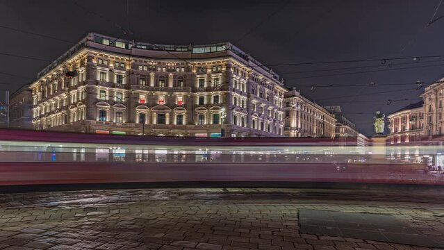 Panorama showing the Cordusio Square night timelapse. Illuminated historic buildings, monument and tram traffic. One of squares in the center of the city at the crossroads of six old streets.