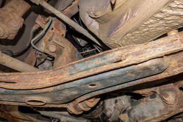 A view of the chassis of an old corroded twenty year old car - obrazy, fototapety, plakaty