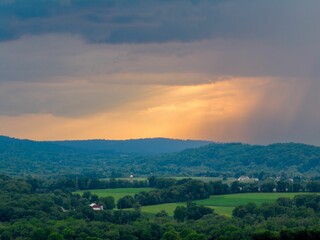 Obraz premium Aerial view of an idyllic rural farm with a spectacular sunset sky in the background