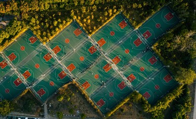 an aerial view of multiple tennis courts in the middle of an urban park