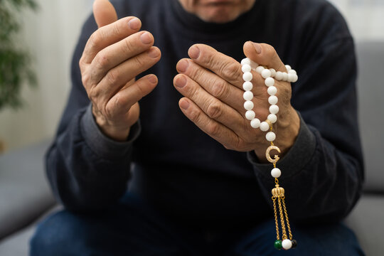 Muslim man hands holding rosary