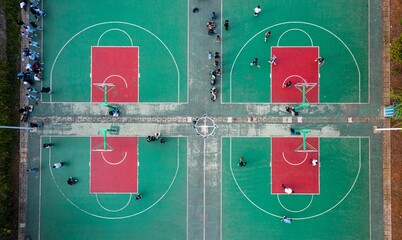 Aerial view of an outdoor court with a group of people playing basketball