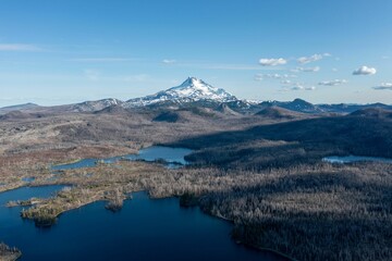 Areal view of a tranquil glacial lake surrounded by snow-capped mountains in the background