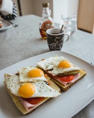 Vertical closeup of sandwiches with eggs and a cup of coffee for breakfast