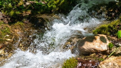 Closeup shot of a flowing splashing stream on rocks in a forest