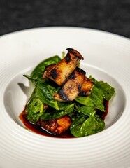 Close-up of a bowl of charcoal-grilled mushrooms and spinach