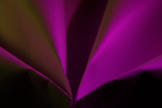 L&iacute;neas de papel reciclado r&uacute;stico para oficina con pliegues en abanicos  convergentes en un punto de perspectiva, con luz violeta, forma un original y hermoso dise&ntilde;o abstracto para fondos de dise&ntilde;o