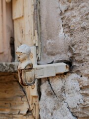 Close-up of a door knocker on the side of an aged structure