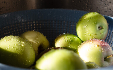 sliced green apples with drops of water, summer, blue basket