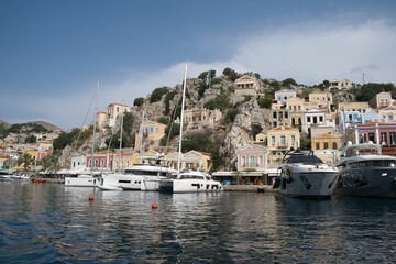 Fototapeta na wymiar Picturesque view of a tranquil town nestled on the shore of the sea in Symi island, Greece.