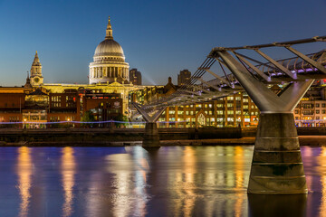 Saint Paul's Cathedral and the Millennium Bridge in London over the River Thames at night