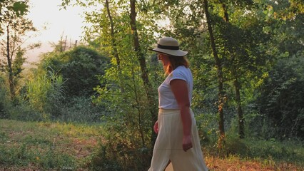 Caucasian Woman Tourist Walking Down Countryside Path Among Trees Orchard near Umbrian Village in Italy