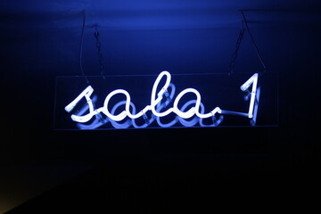 Blue neon sign indicating room 1